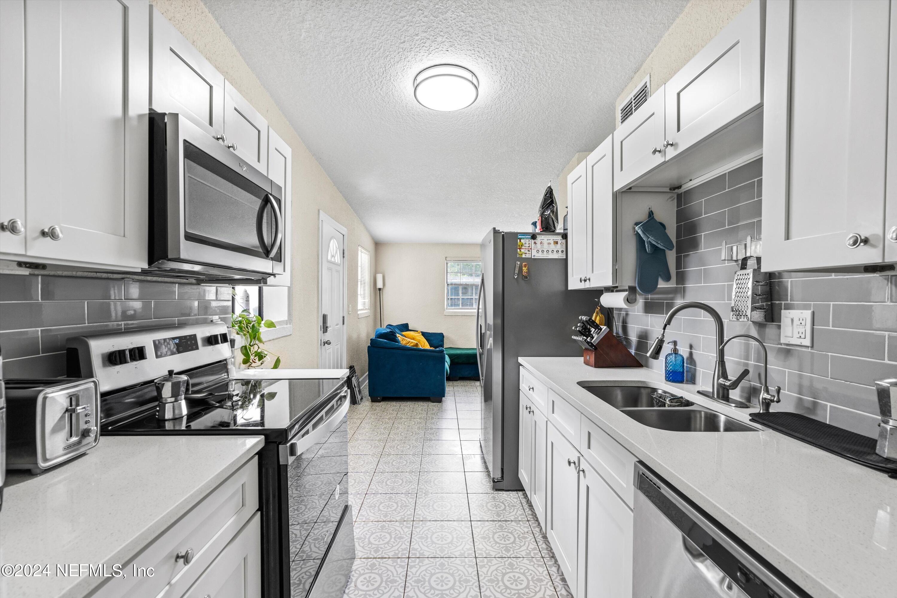 1824 Griflet Road Jacksonville, FL 32211 - Photo 6 of 19 a kitchen with stainless steel appliances a stove sink microwave and cabinets