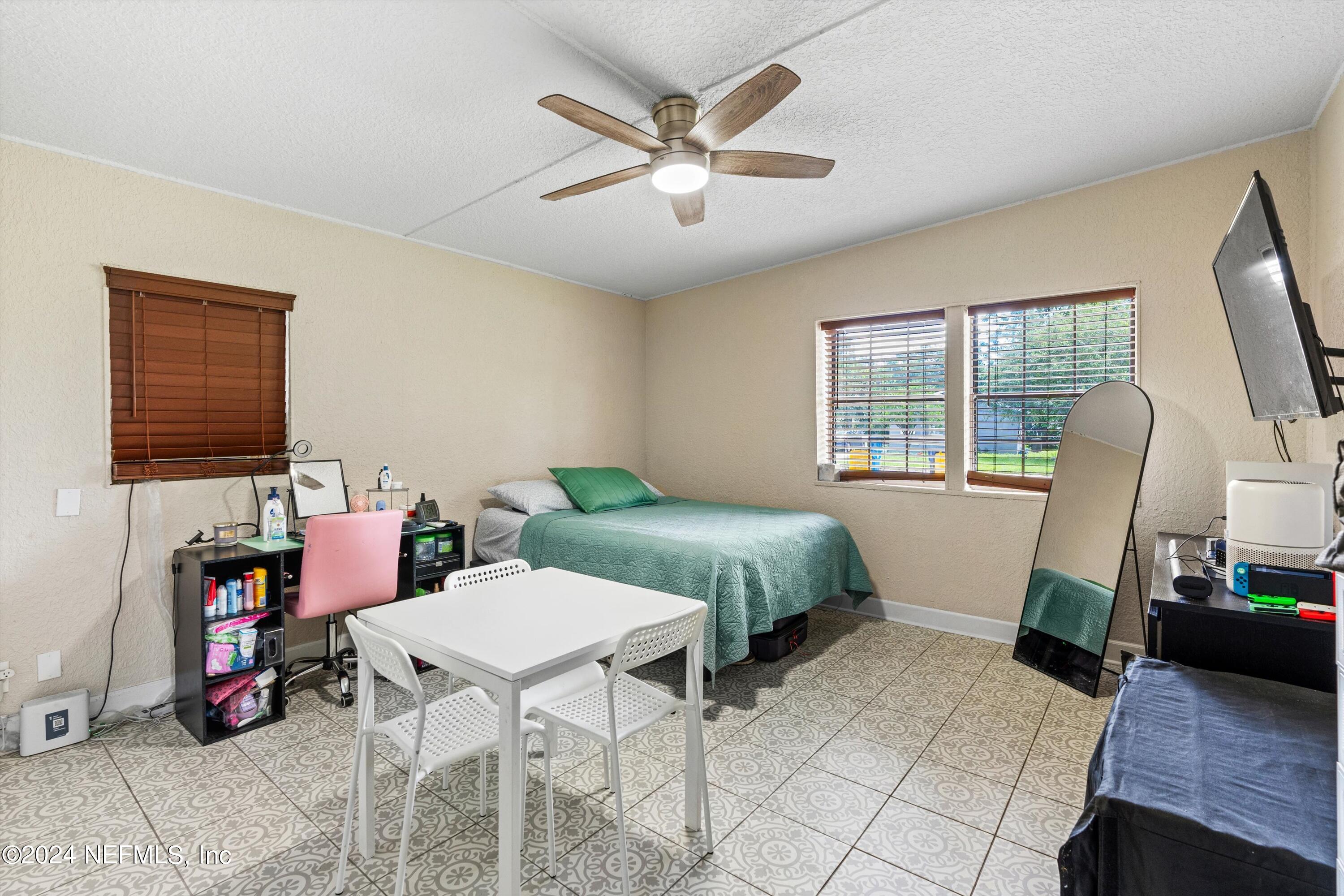 1824 Griflet Road Jacksonville, FL 32211 - Photo 8 of 19 a bedroom with a bed a computer on desk and a dresser next to a window