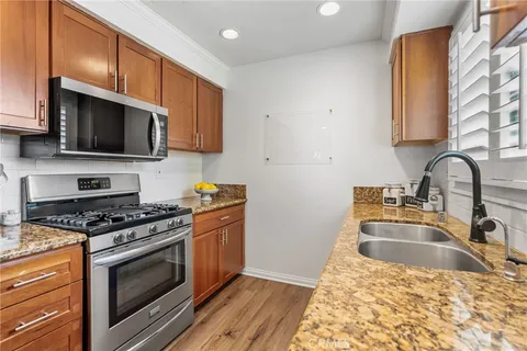 a kitchen with granite countertop a sink a stove and microwave