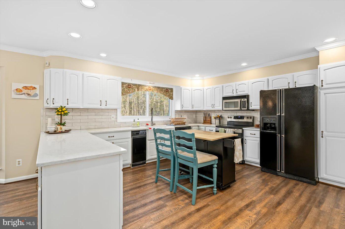 13037 Orange Plank Road Locust Grove, VA 22508 - Photo 21 of 71 a kitchen with a refrigerator a stove and a microwave with wooden floor