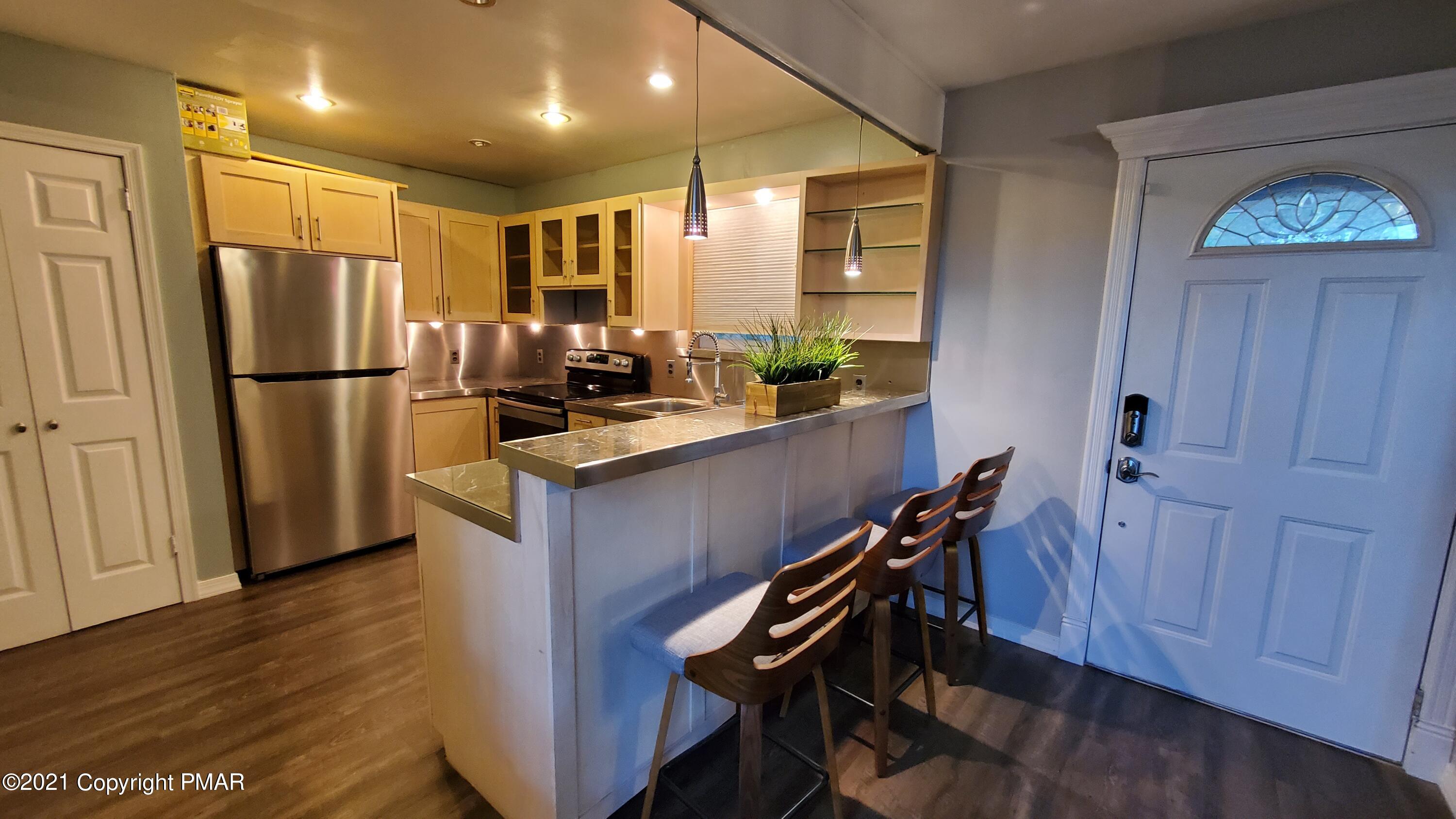 2111 Southport Drive Bushkill, PA 18324 - Photo 24 of 30 a kitchen with kitchen island a counter top space a sink a refrigerator and cabinets