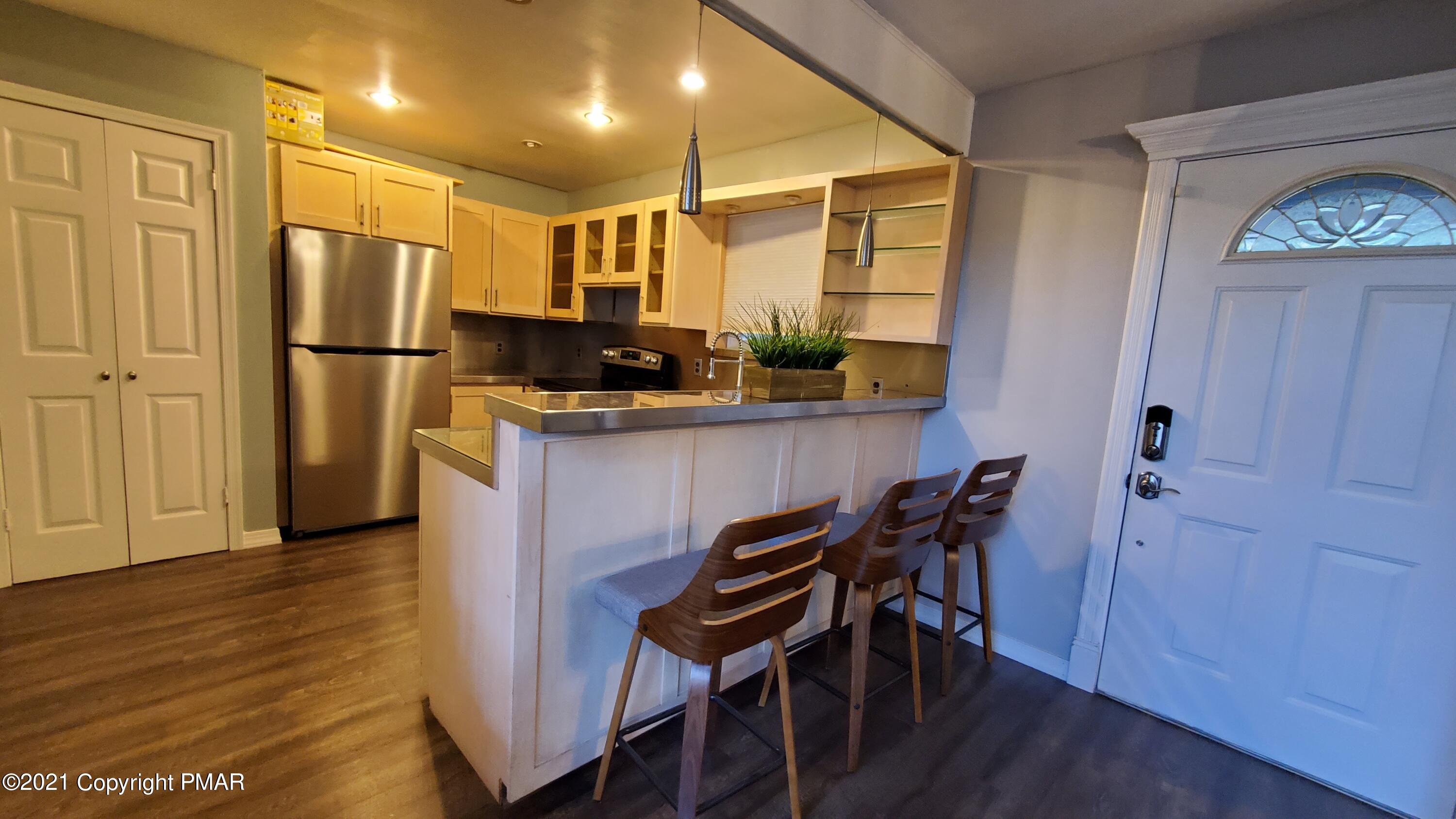 2111 Southport Drive Bushkill, PA 18324 - Photo 4 of 30 a kitchen with stainless steel appliances granite countertop a refrigerator a stove and a wooden floors