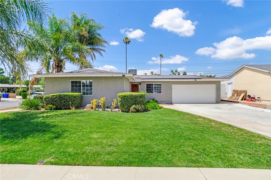 a view of a house with a yard and a garage