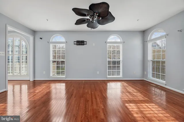 a view of kitchen with stainless steel appliances granite countertop a stove top oven a refrigerator a sink and a dining table with wooden floor