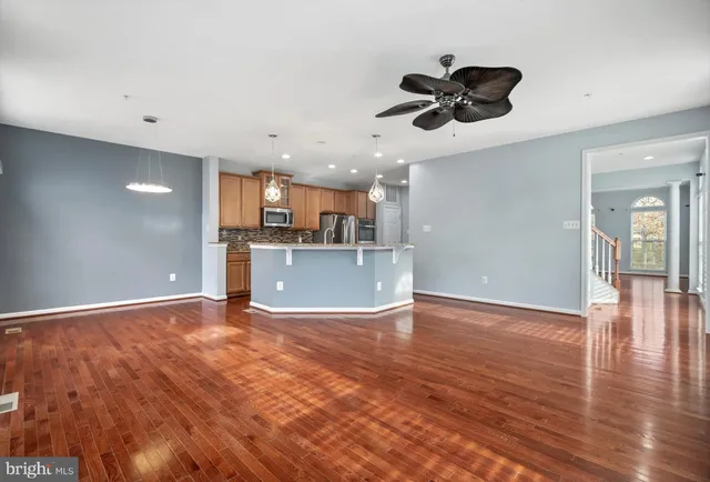 a view of kitchen with granite countertop cabinets stove and wooden floor