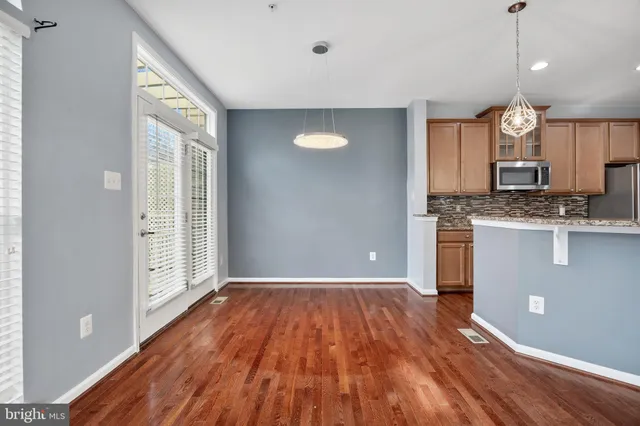 a kitchen with stainless steel appliances granite countertop a sink a stove and a wooden floors