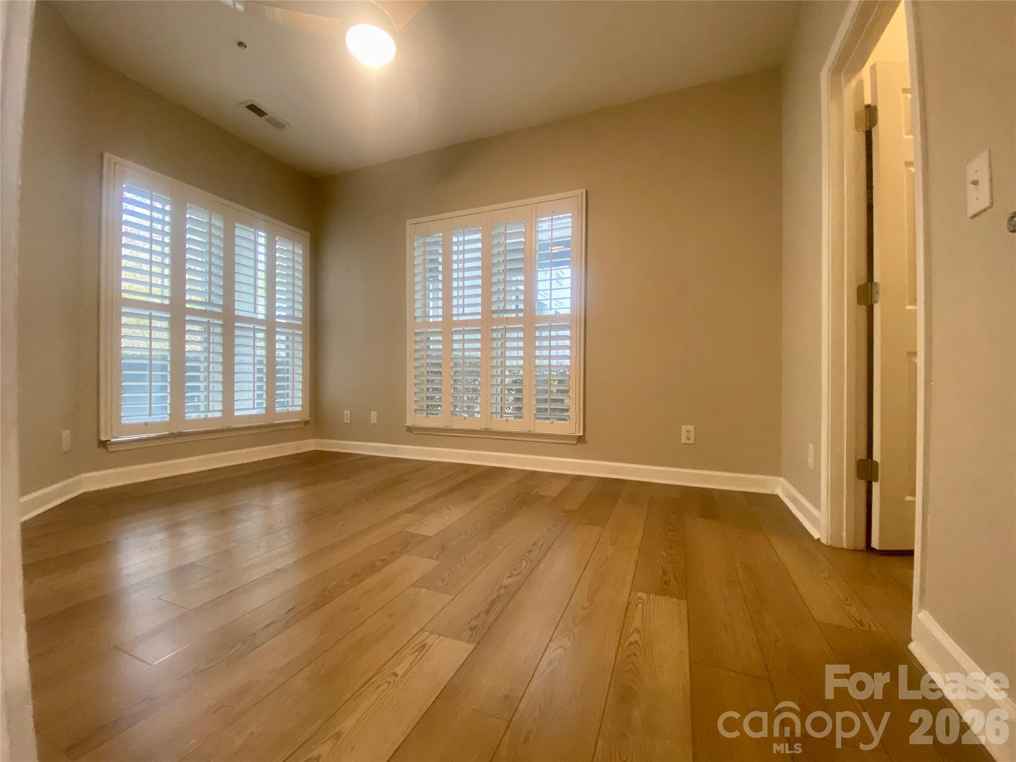 920 Jetton Street, Unit 49 Davidson, NC 28036 - Photo 22 of 33 a view of an empty room with glass door and wooden floor