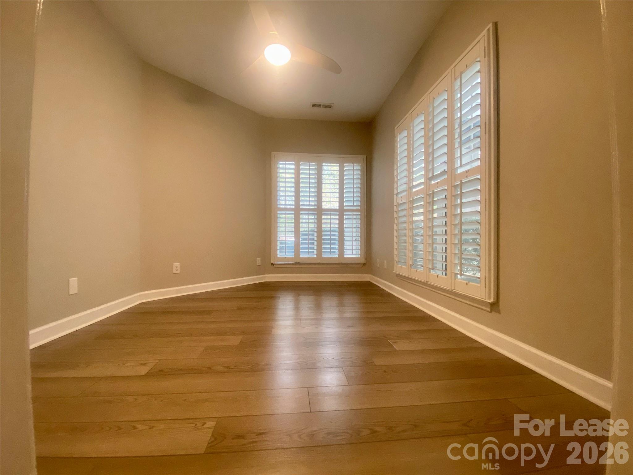 920 Jetton Street, Unit 49 Davidson, NC 28036 - Photo 23 of 33 an empty room with wooden floor and windows