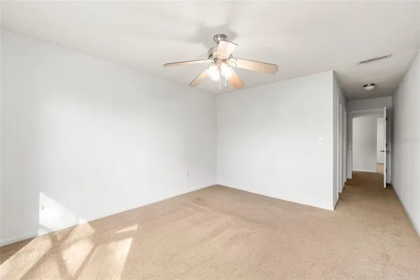 an empty room with fan and entrance