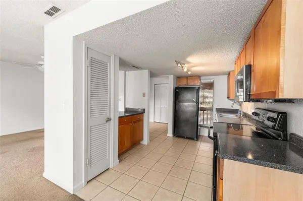 a kitchen with stainless steel appliances granite countertop a refrigerator and a sink