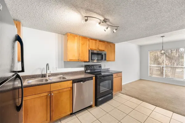 a kitchen with stainless steel appliances granite countertop a sink stove and cabinets