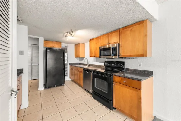 a kitchen with stainless steel appliances granite countertop a stove refrigerator and microwave