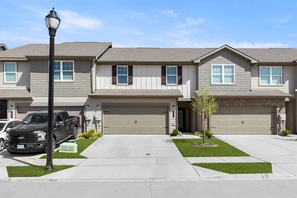 a front view of a house with a garden and parking