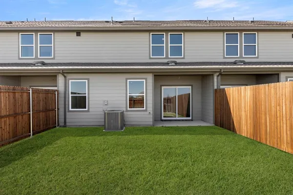 a view of a house with a yard and wooden fence