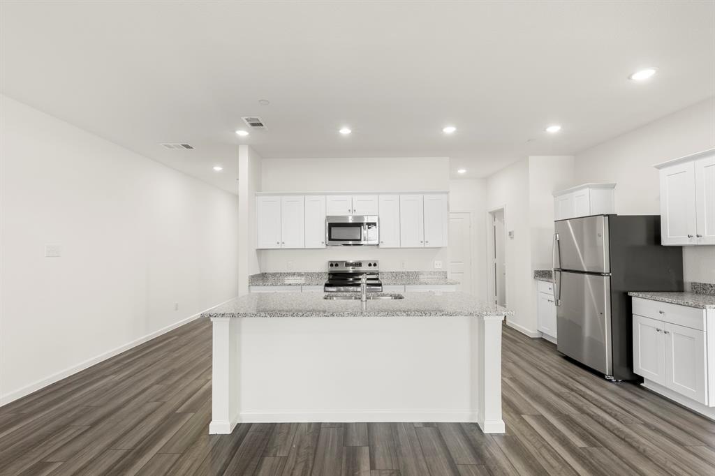 1444 Lake Alpine Trail Anna, TX 75409 - Photo 7 of 29 a kitchen with stainless steel appliances a white refrigerator a sink dishwasher a oven with white cabinets and wooden floor