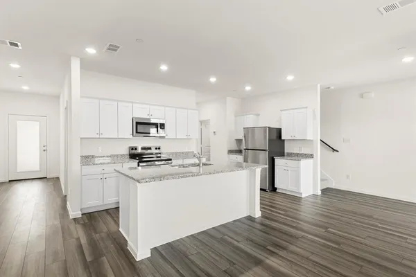 a kitchen with stainless steel appliances kitchen island wooden cabinets and granite counter tops
