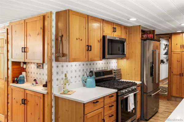 a kitchen with stainless steel appliances a stove microwave and refrigerator