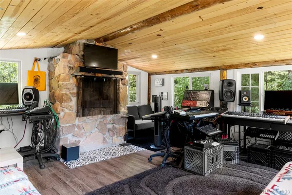 a living room with furniture a flat screen tv and floor to ceiling window
