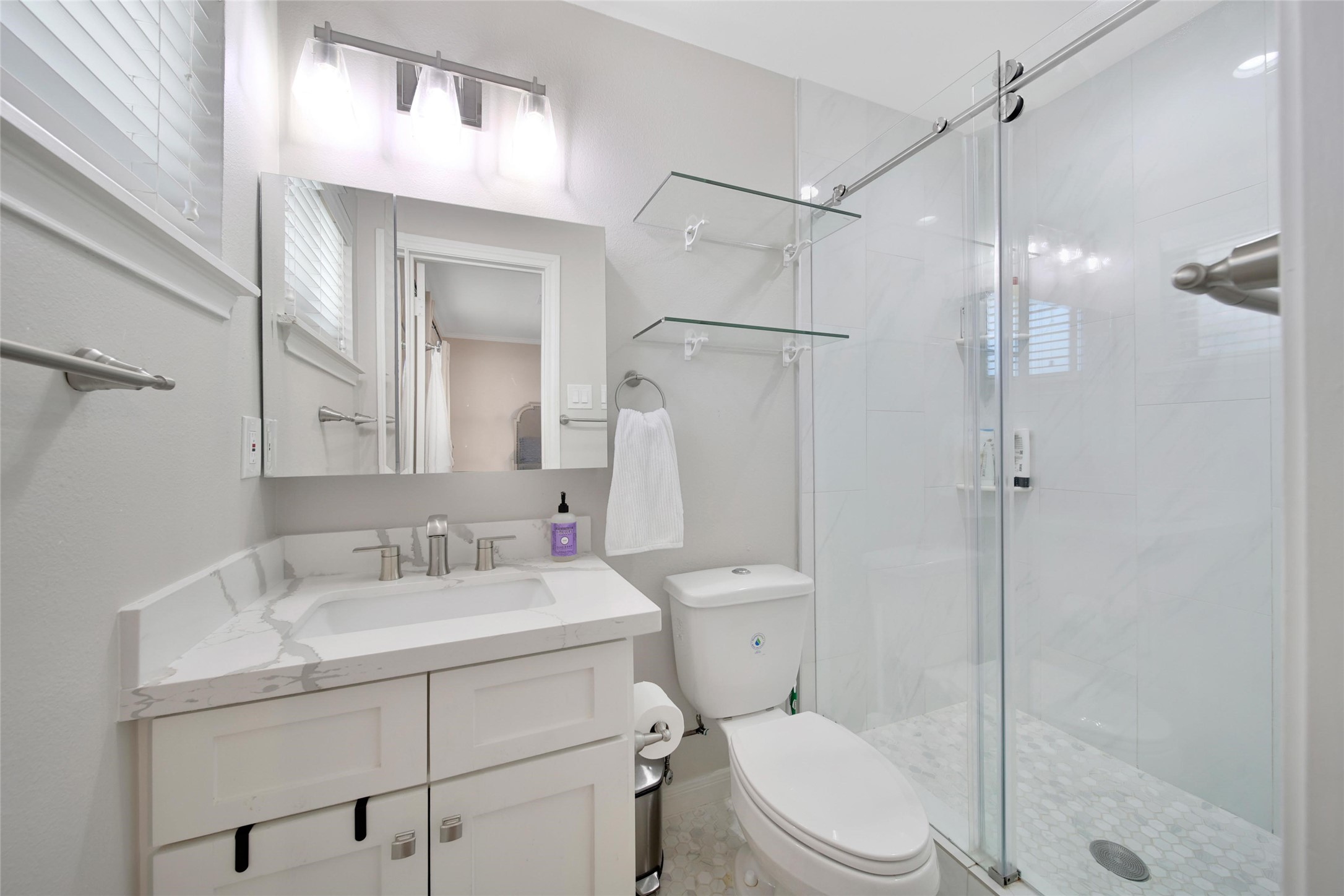 4402 Fallbrook Drive Houston, TX 77018 - Photo 21 of 29 Beautifully renovated primary bath with a sleek walk-in shower, quartz vanity, and contemporary fixtures.