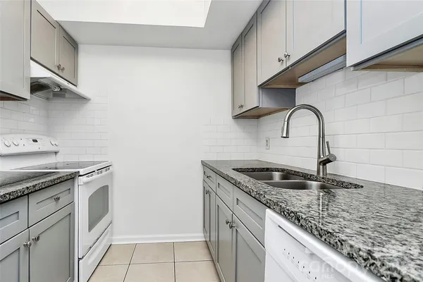 a kitchen with granite countertop a sink and cabinets
