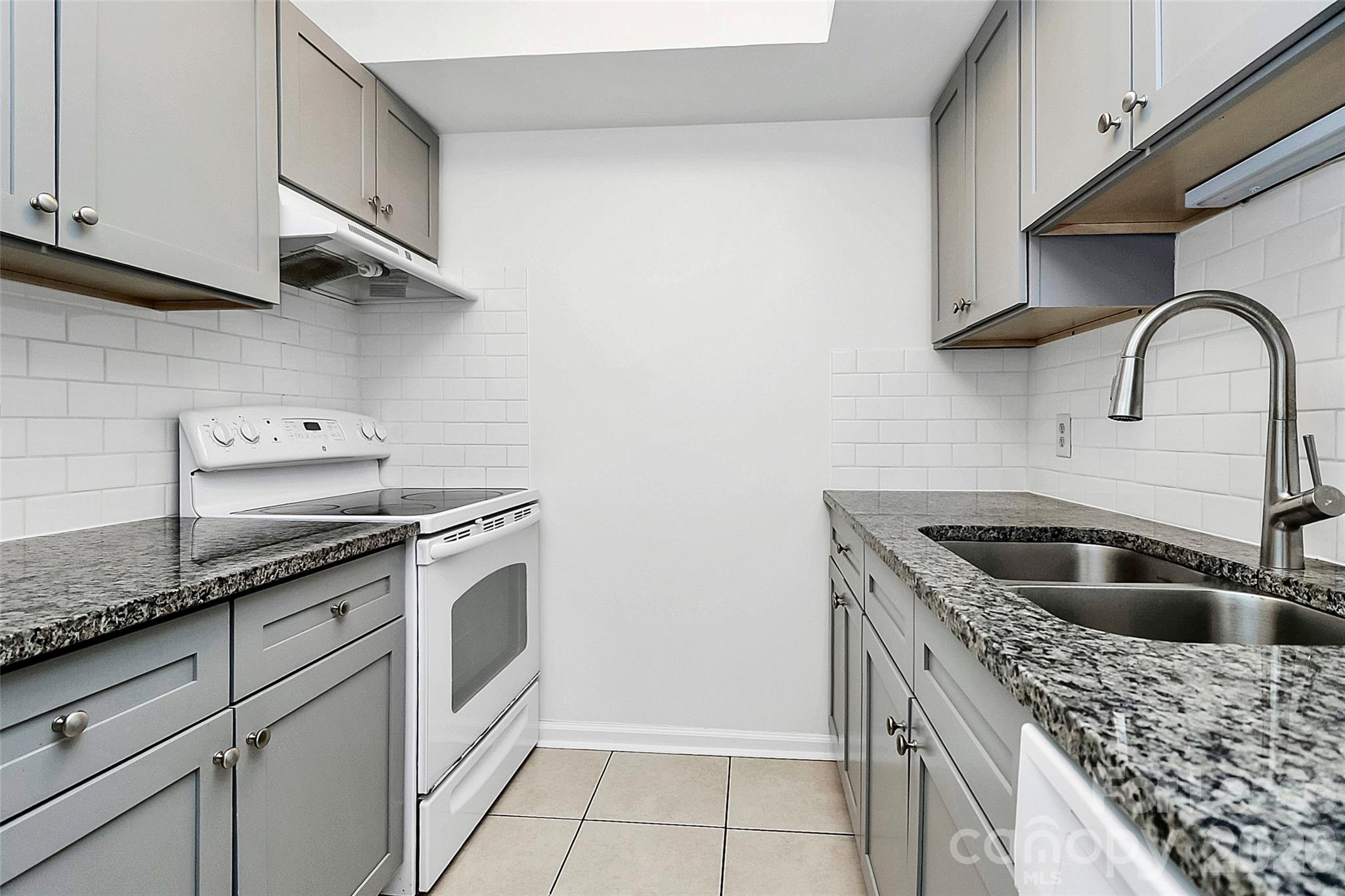 430 Queens Road, Unit 711 Charlotte, NC 28204 - Photo 10 of 20 a kitchen with granite countertop a sink and a stove top oven
