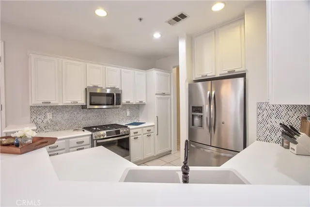 a kitchen with stainless steel appliances granite countertop a refrigerator and a stove
