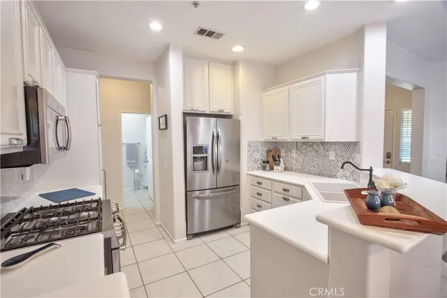 a kitchen with cabinets stainless steel appliances and a counter space