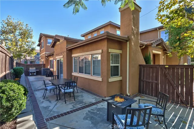 a view of a patio with table and chairs potted plants and wooden fence