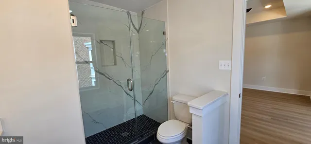 a view of empty room with wooden floor and window