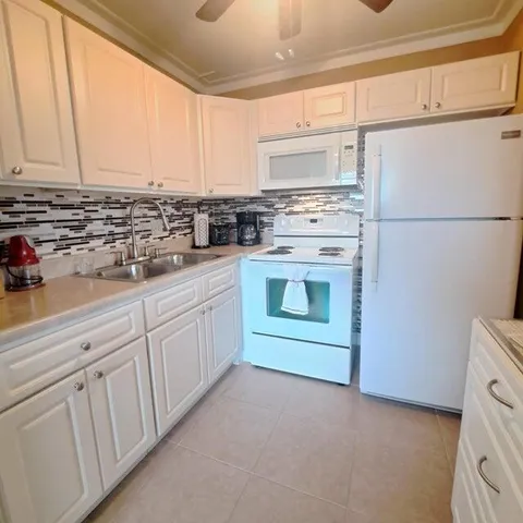 a kitchen with white cabinets and white appliances