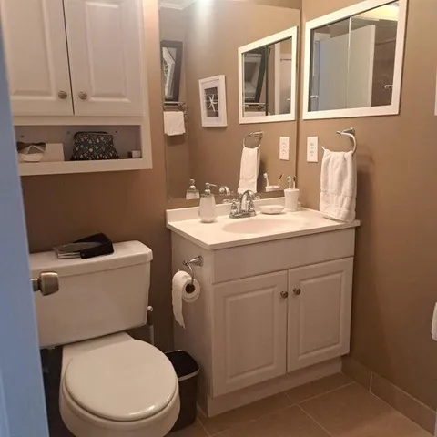 a bathroom with a toilet sink and mirror