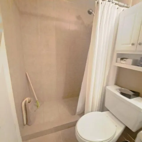 a white toilet sitting next to a bath tub
