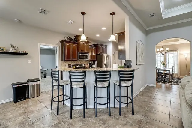 a kitchen with stainless steel appliances kitchen island granite countertop a table and chairs in it