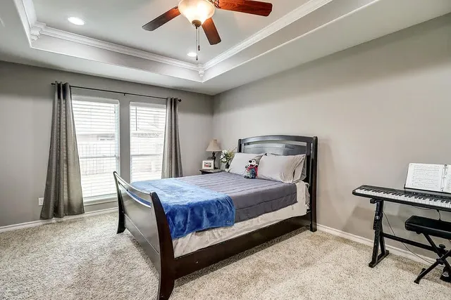 a bedroom with a bed desk and a window