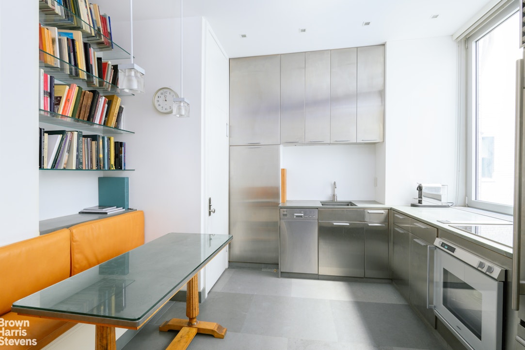 1000 Park Avenue, Unit 7F Manhattan, NY 10028 - Photo 4 of 7 a kitchen with stainless steel appliances granite countertop a sink dishwasher stove and refrigerator
