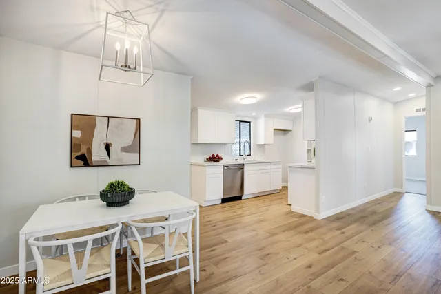 a kitchen with stainless steel appliances granite countertop a table chairs and a refrigerator