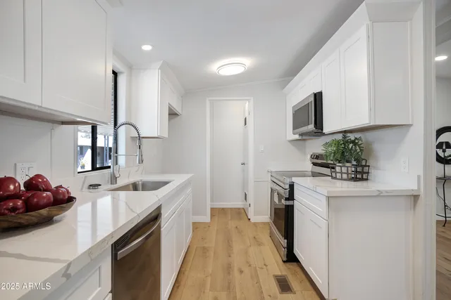 a kitchen with stainless steel appliances a sink stove and cabinets