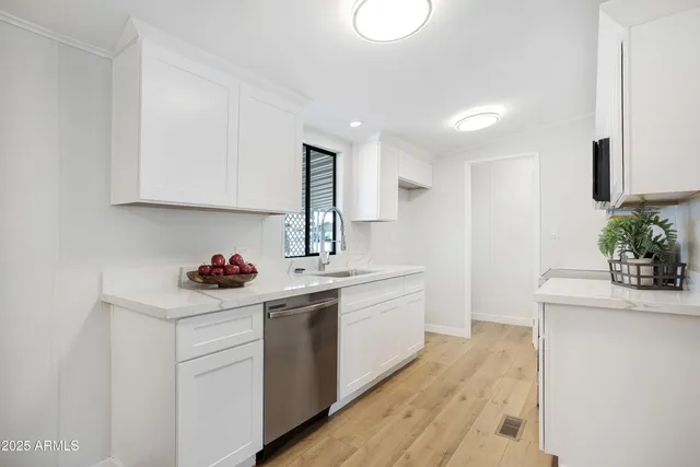 a kitchen with a sink cabinets and wooden floor
