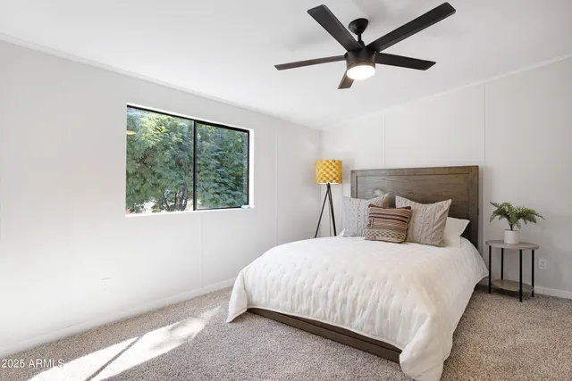 a bedroom with a bed and a large window