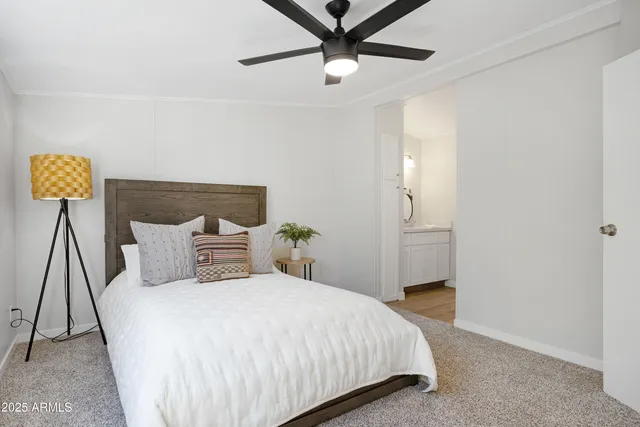 a bedroom with a bed and painting on the wall