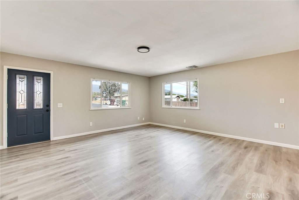 582 Wesley Street Banning, CA 92220 - Photo 12 of 49 an empty room with wooden floor and windows