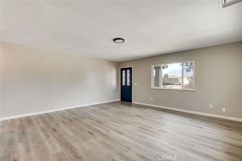 582 Wesley Street Banning, CA 92220 - Photo 13 of 49 a view of an empty room with wooden floor and a window