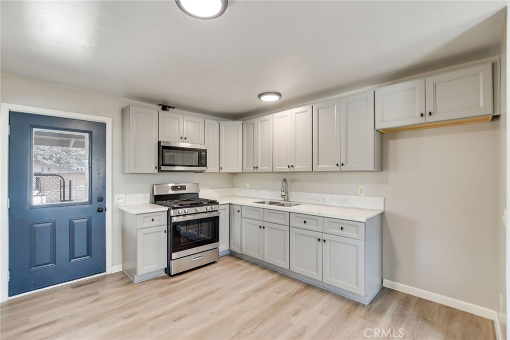 582 Wesley Street Banning, CA 92220 - Photo 16 of 49 a kitchen with granite countertop white cabinets and stainless steel appliances