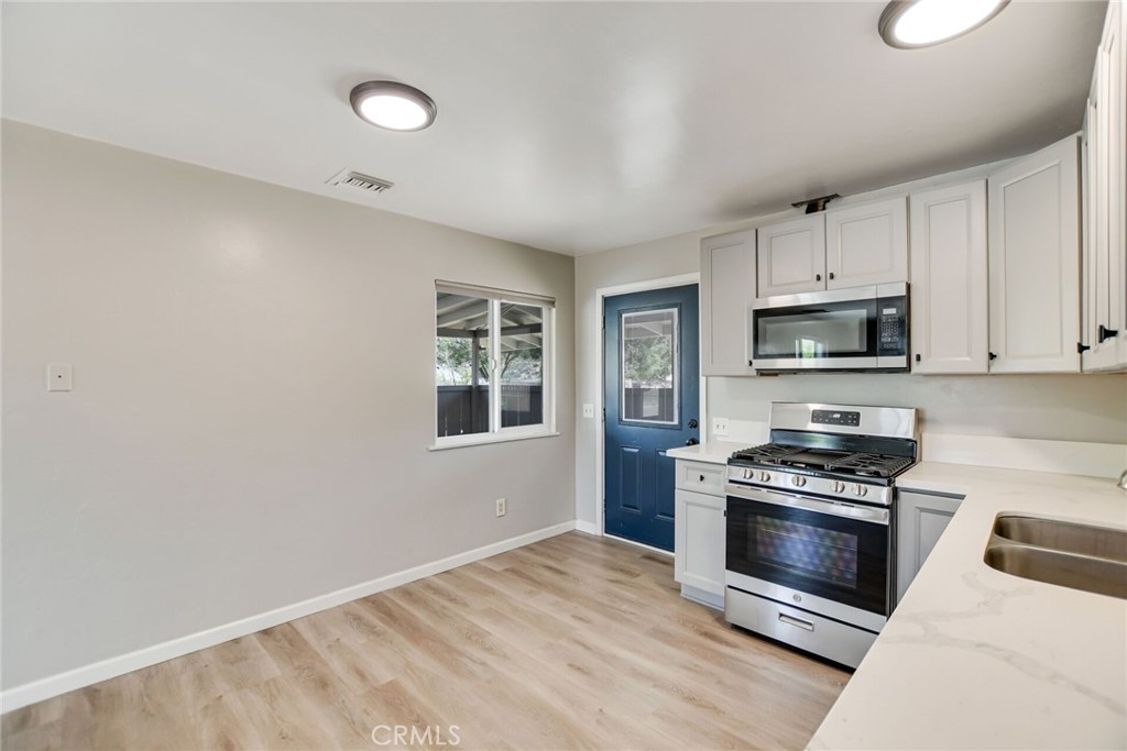 582 Wesley Street Banning, CA 92220 - Photo 18 of 49 a kitchen with granite countertop a stove a sink and a microwave