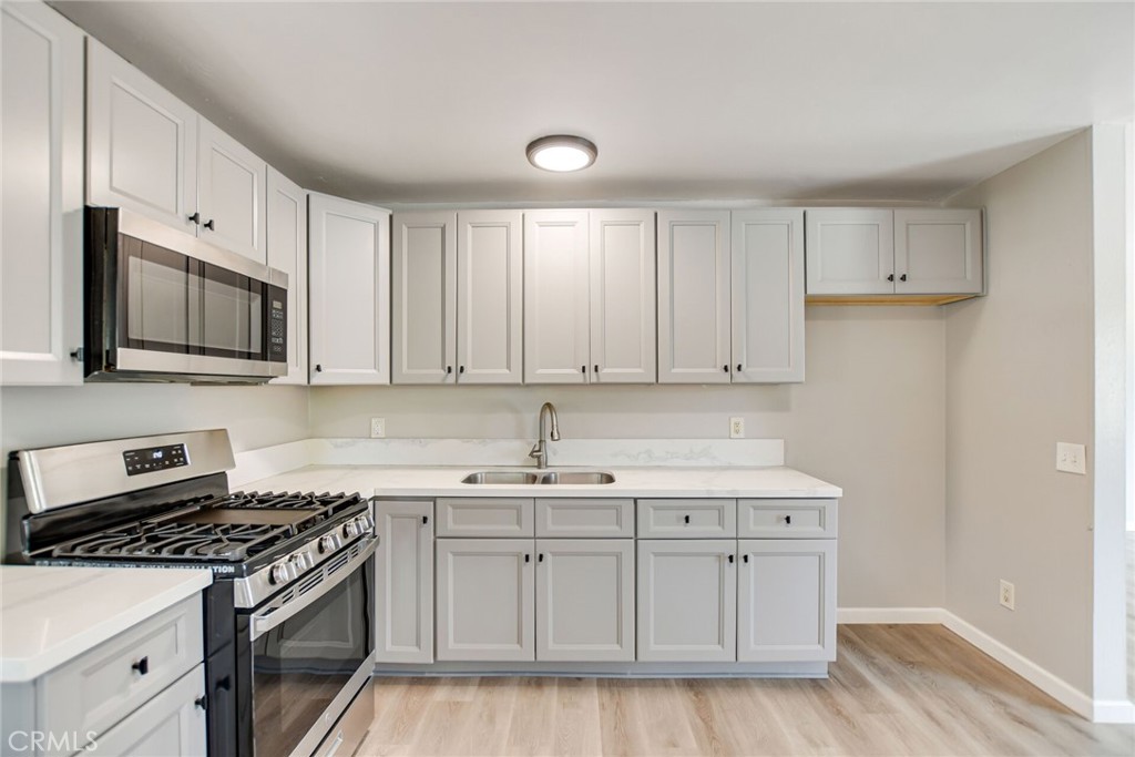 582 Wesley Street Banning, CA 92220 - Photo 21 of 49 a kitchen with a sink stove top oven and cabinets