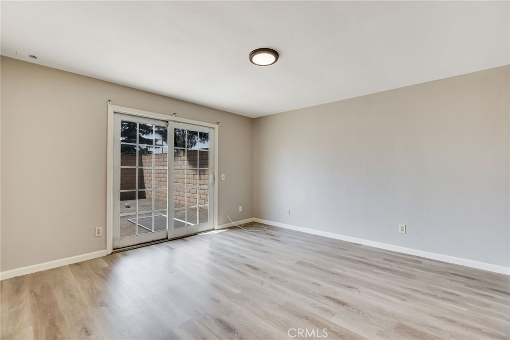 582 Wesley Street Banning, CA 92220 - Photo 22 of 49 an empty room with wooden floor and windows