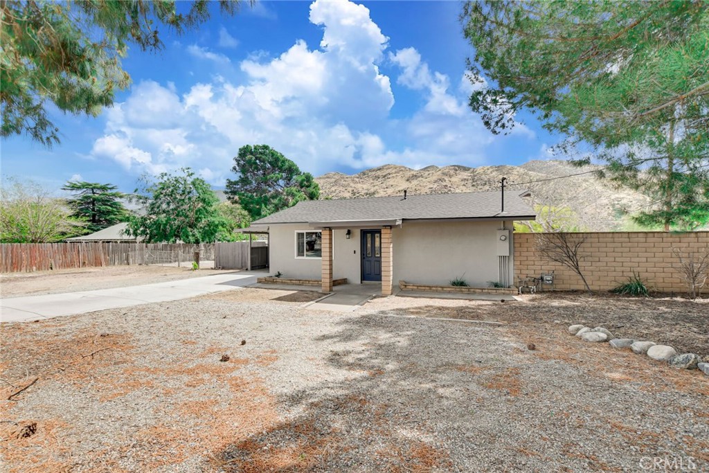 582 Wesley Street Banning, CA 92220 - Photo 9 of 49 a view of a house with a tree and a yard
