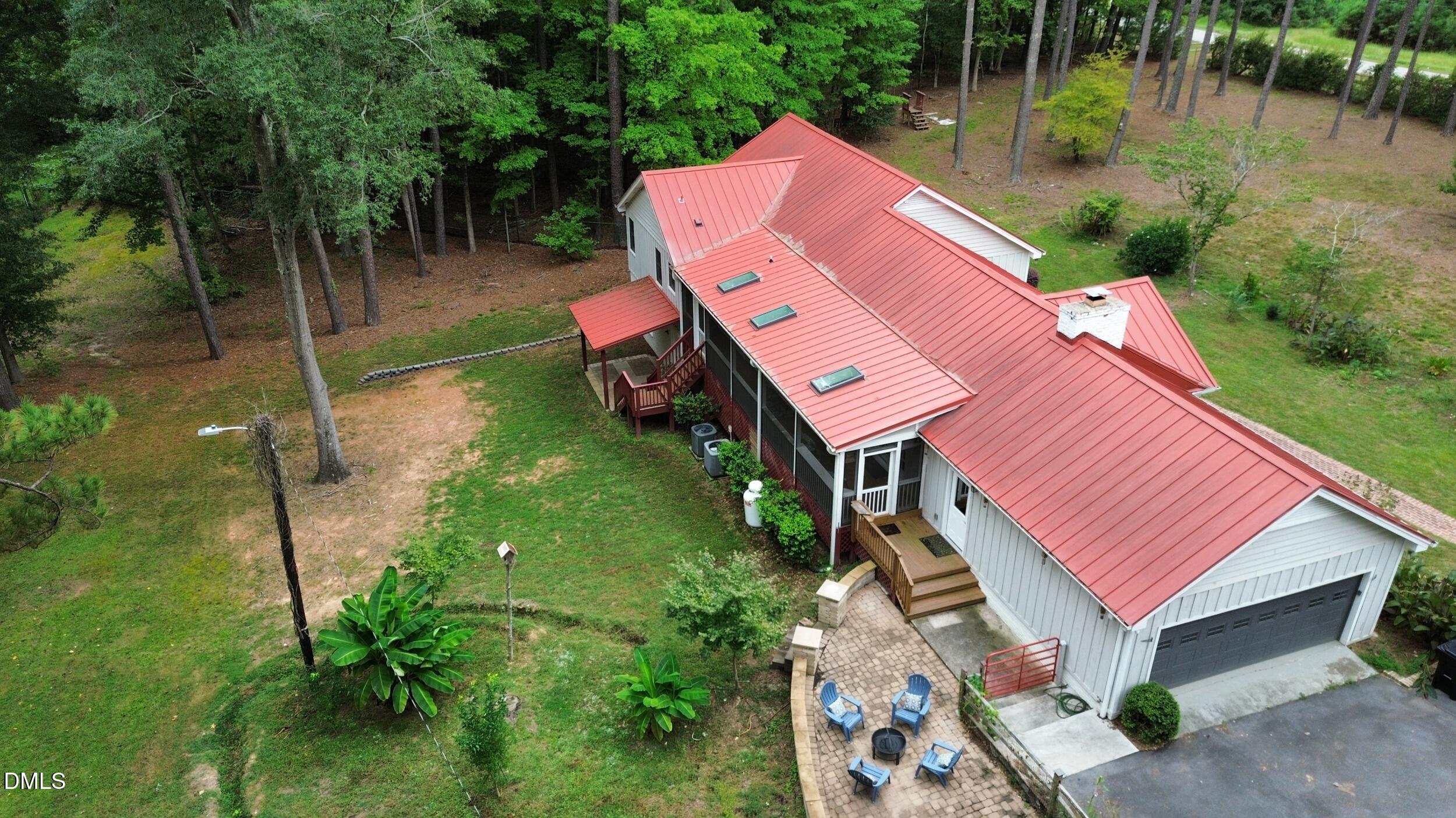 2329 Win Road Garner, NC 27529 - Photo 82 of 90 Light gray siding exterior with a red metal roof, skylights, and a two-car garage