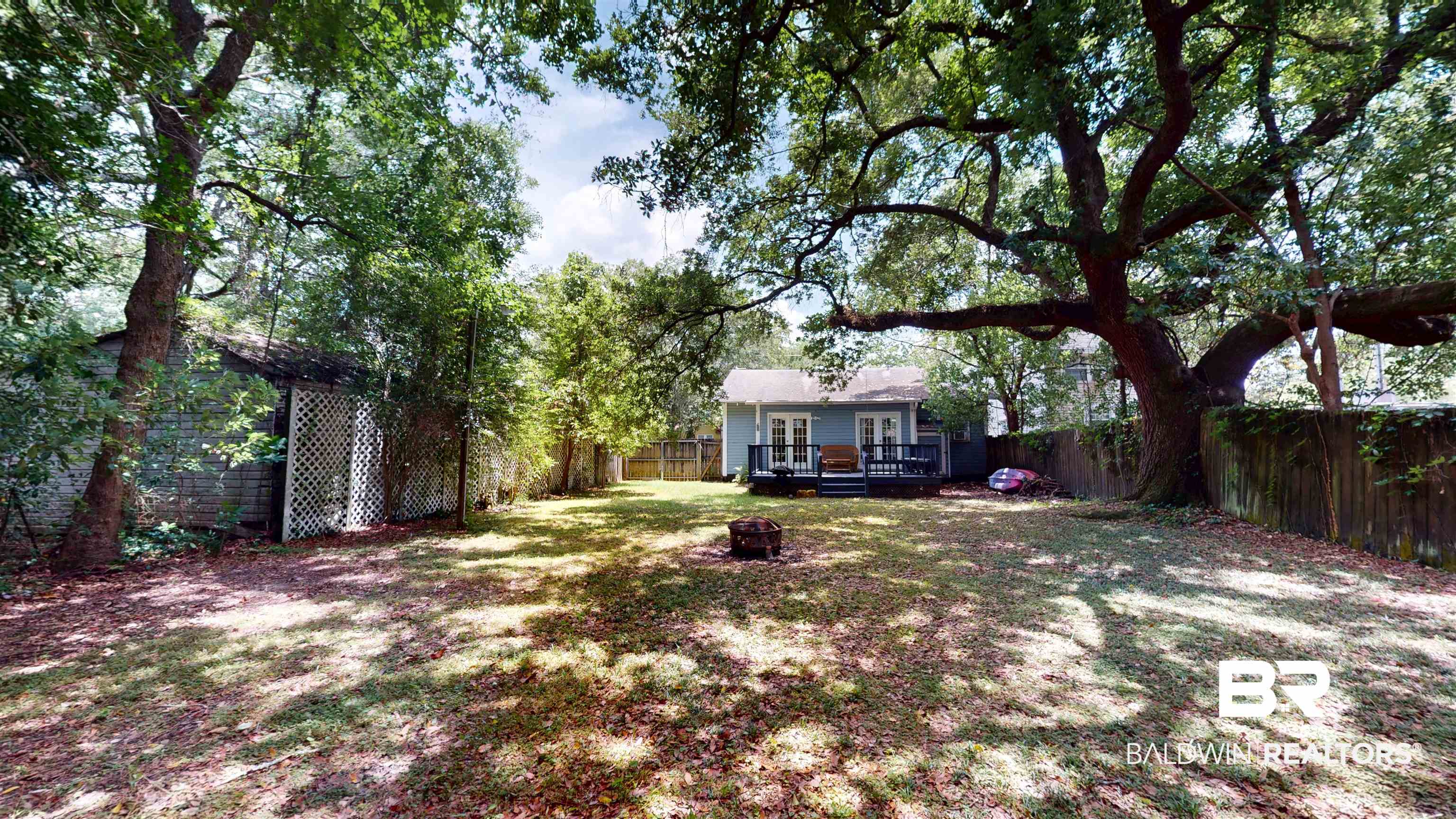 266 Westwood Street Mobile, AL 36606 - Photo 29 of 34 Fenced backyard featuring a wooden deck, an outdoor fire pit, and french doors