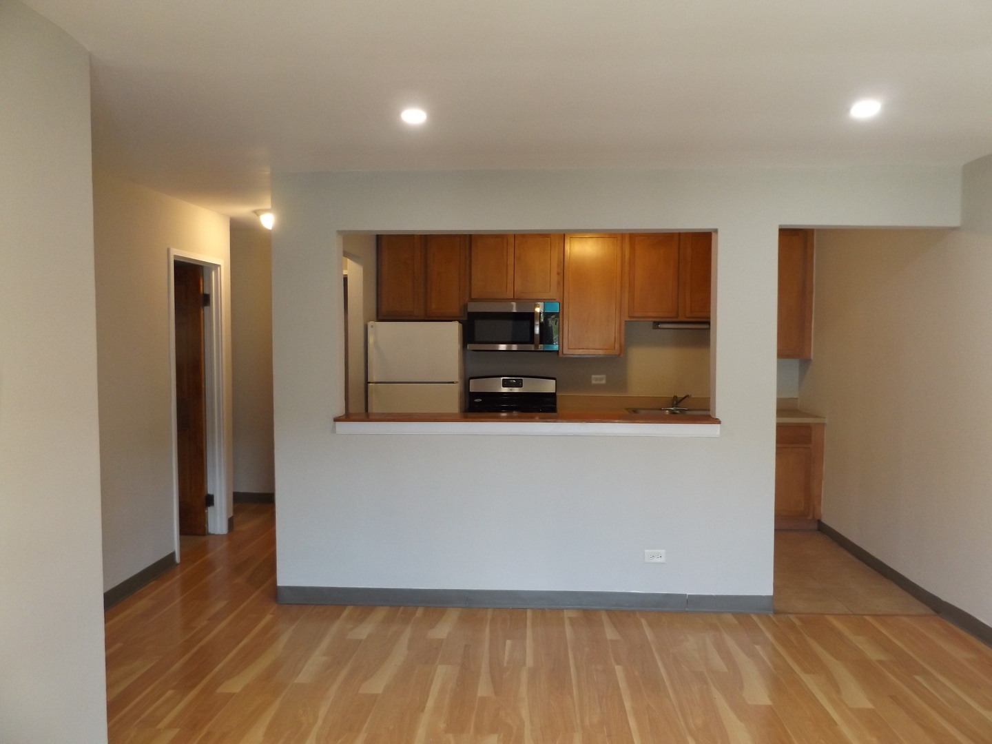 710 West Huntington Commons Road, Unit 1A Mount Prospect, IL 60056 - Photo 6 of 10 a living room with large window and a wooden floor